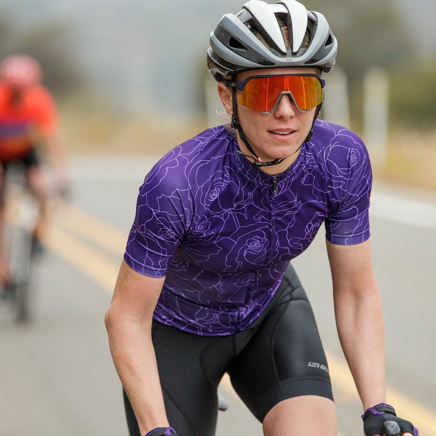 female road cyclist wearing motion jersey in purple