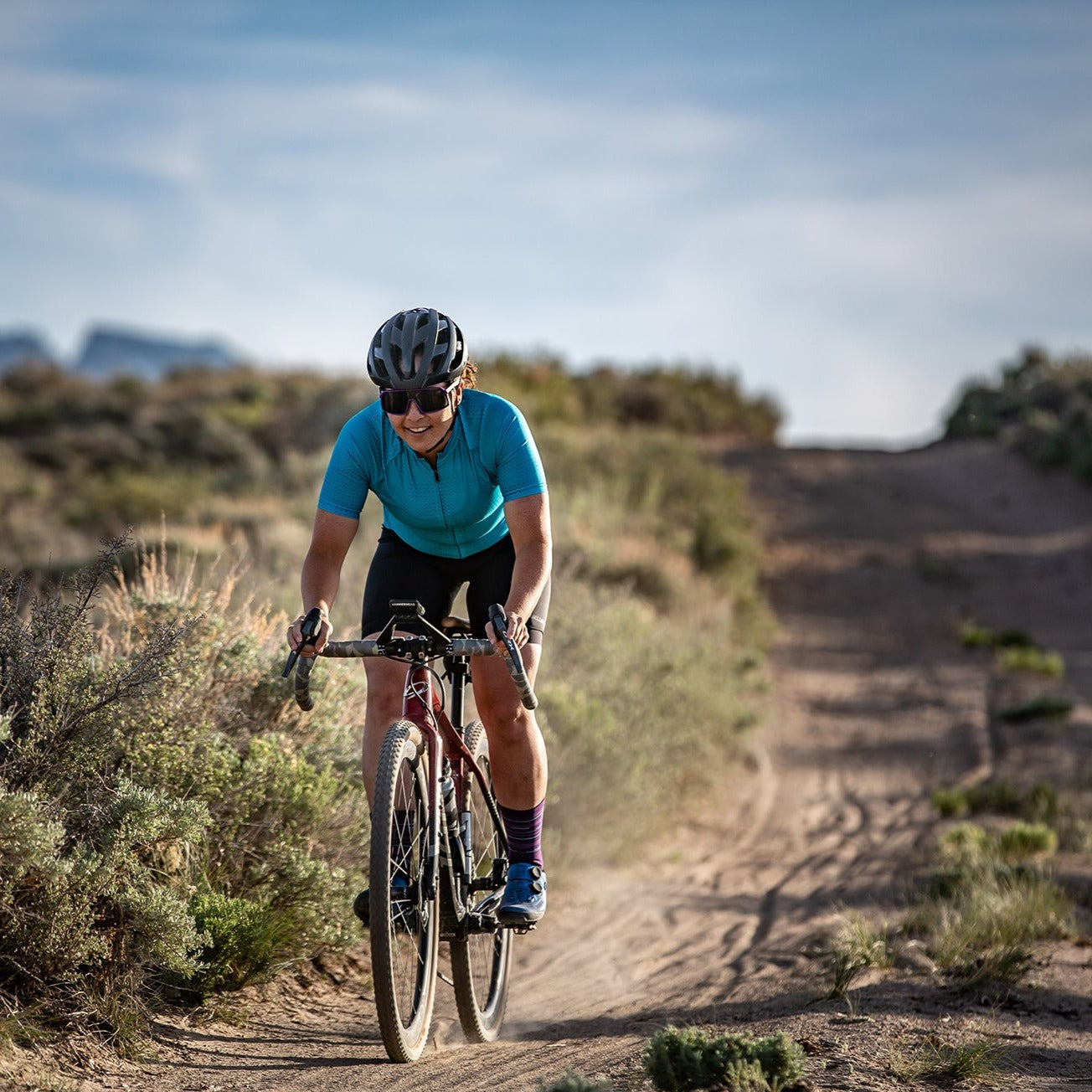 gravel cyclist having fun riding down long road
