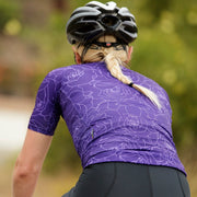 road cyclist wearing purple motion jersey showing back panel